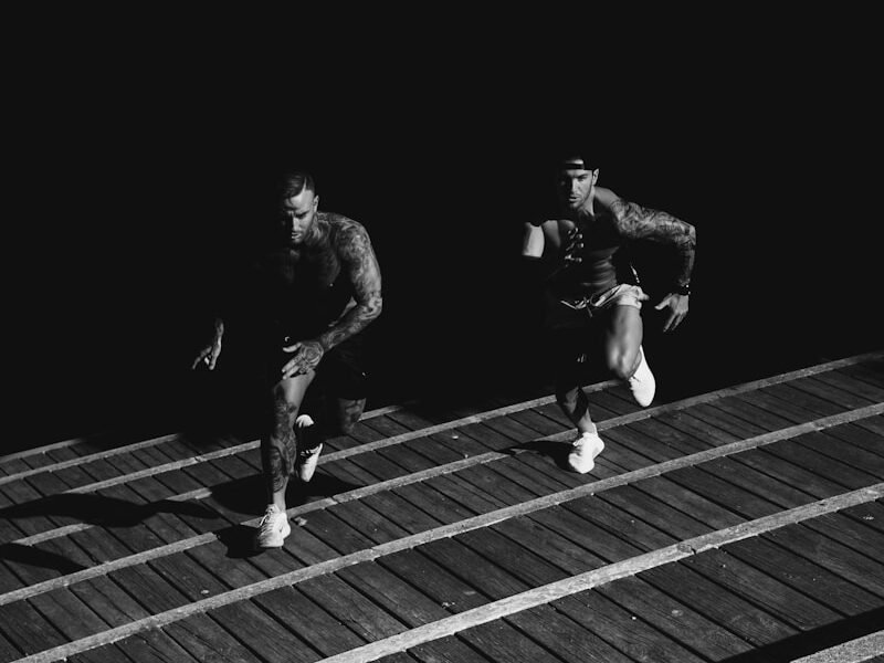 grayscale photo of two men racing each other