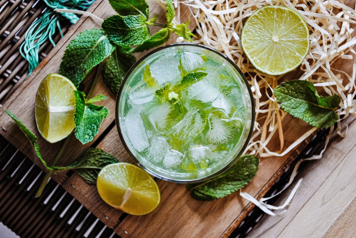 a glass of mojito with limes and mints